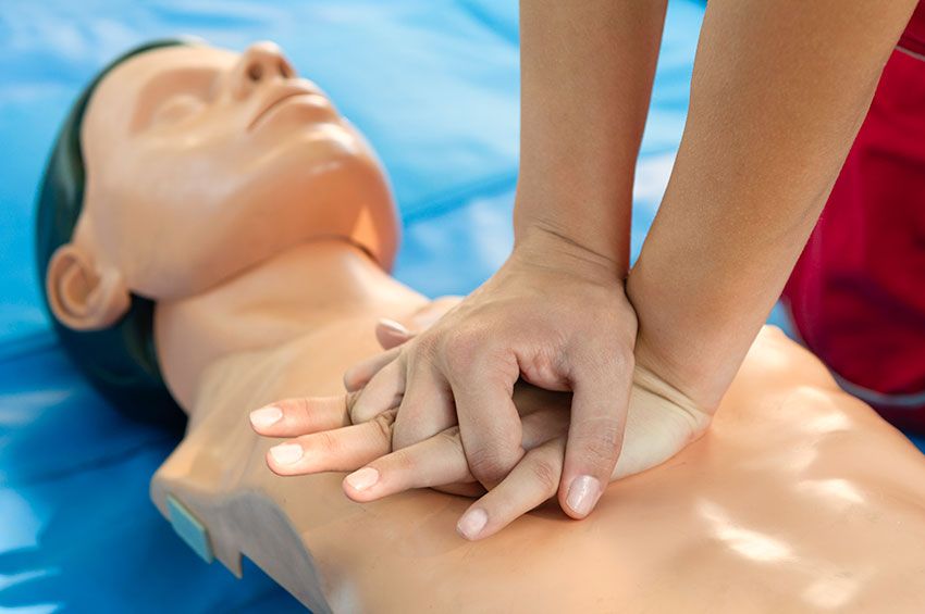 A person giving CPR to a dummy